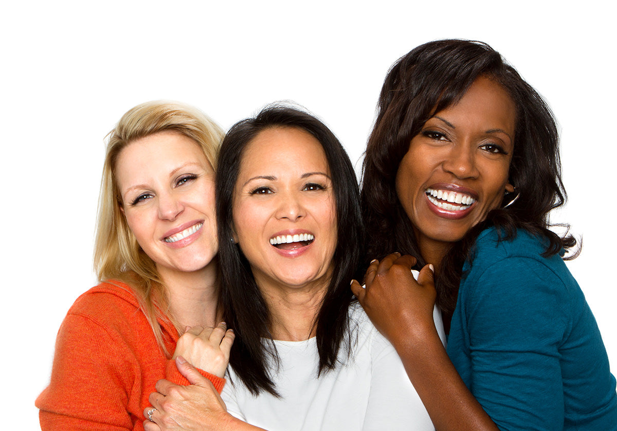 Thee Mature women laughing together in front of a white background