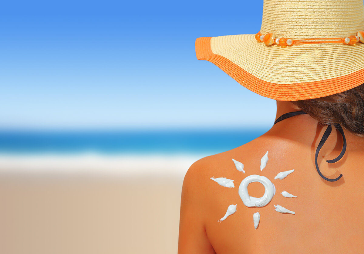 Image of woman sitting on beach in sunshine