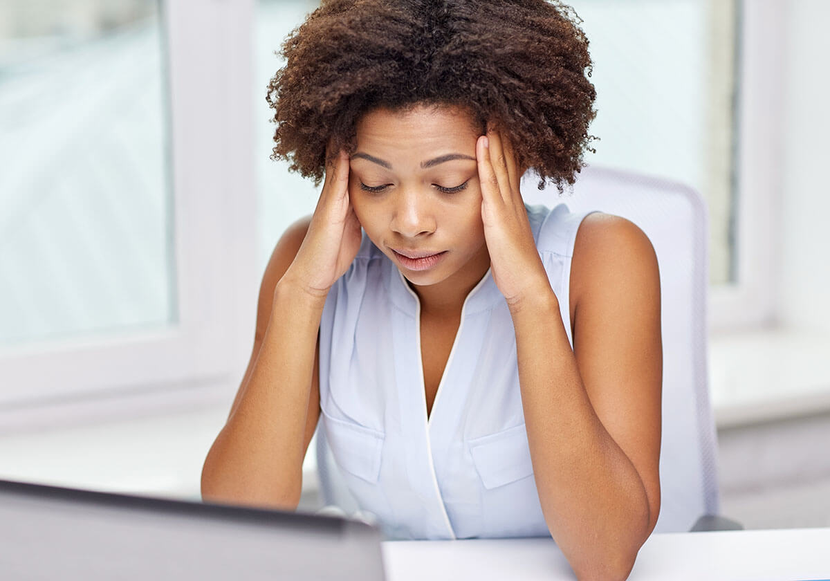 woman stressed out and rubbing her temples.