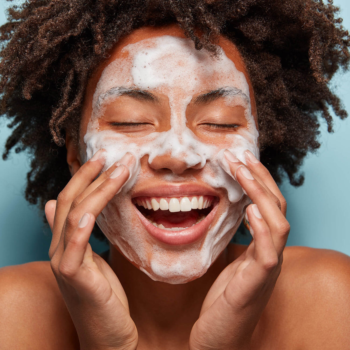 Image of woman cleansing her face | face cleansing products