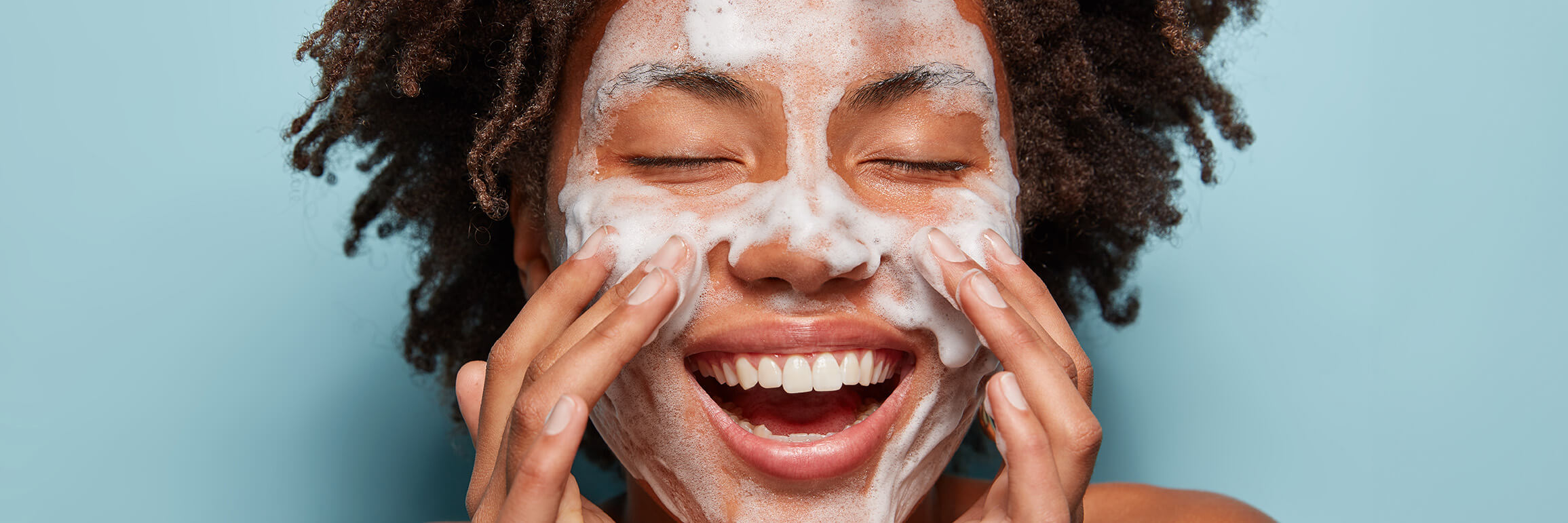 Image of woman cleansing her face | face cleansing products