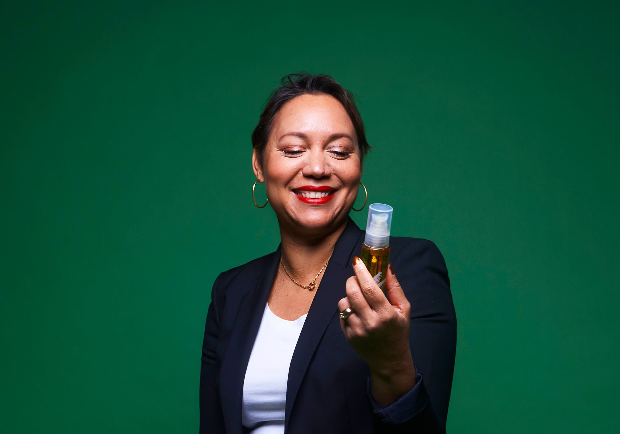 Founder Shirley Billot holding a bottle of Radiance Oil