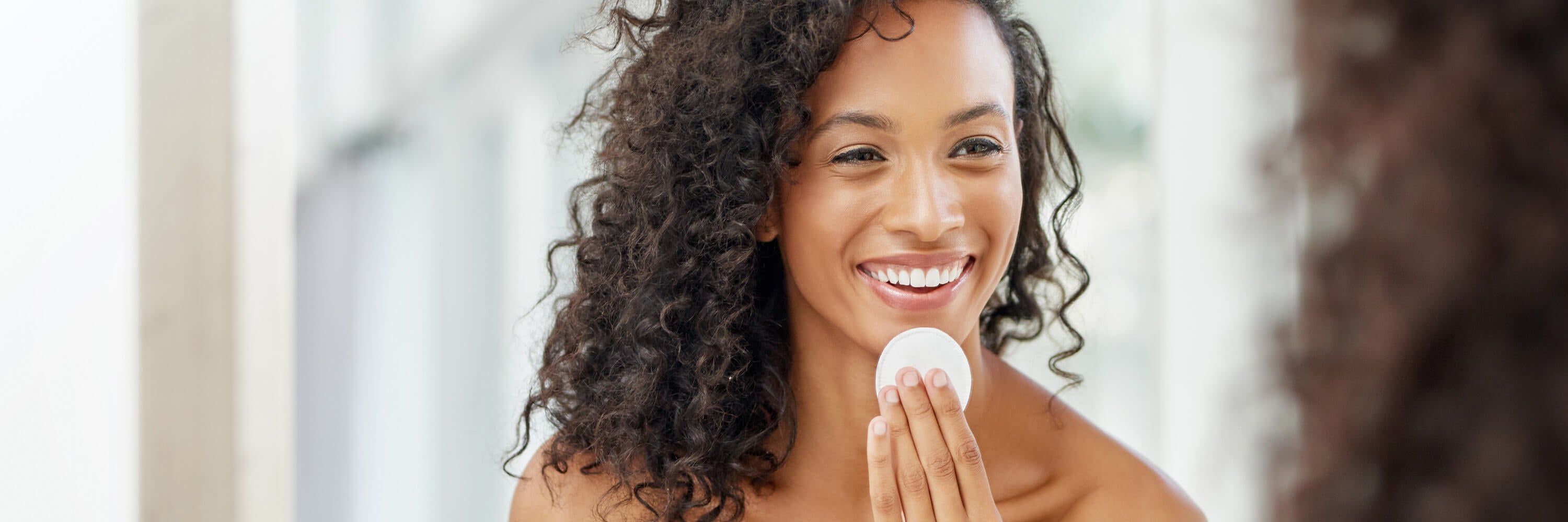 Black woman applying toner to her her face | Kadalys natural vegan exfoliators and toners for face