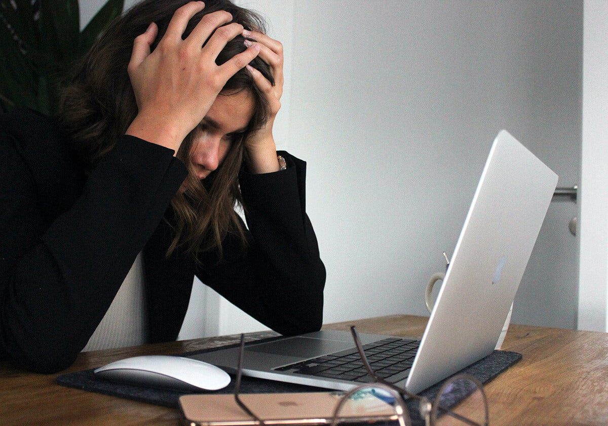 Woman near computer experiencing stress
